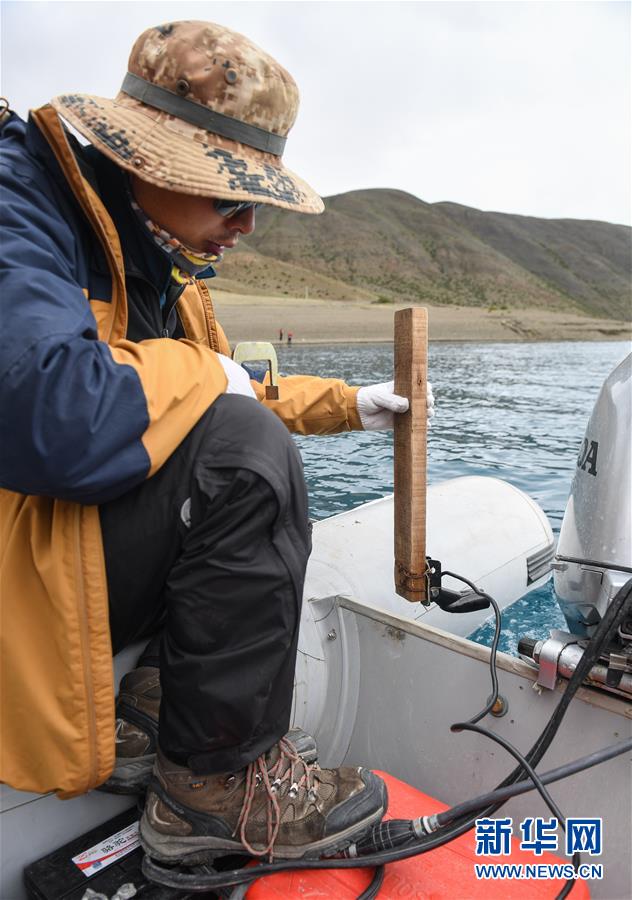 과학탐사대 대원이 수중 지형을 파악하는 데 사용되는 초음파탐지기를 들고 있다. [사진 출처: 신화망]