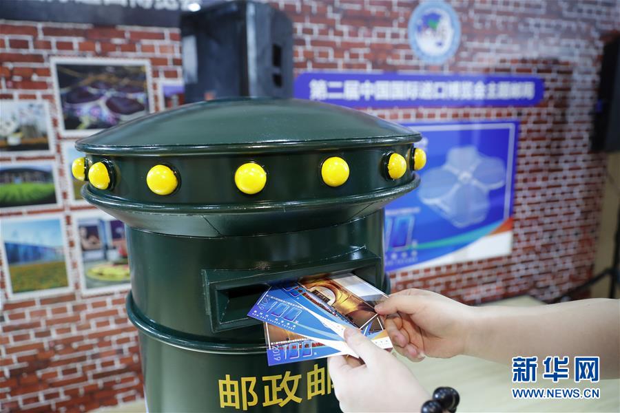 7월 25일, 기념식 참가자가 제2회 중국국제수입박람회 주문제작 우편엽서를 우체통에 넣고 있다. [사진 출처: 신화망]