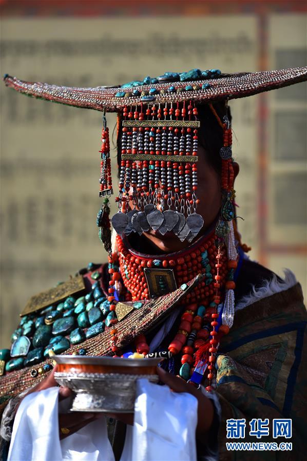 전통의상을 입은 커자(科迦)촌 여성이 마을을 찾은 손님들에게 청과주(靑稞酒)를 대접하고 있다. [사진 출처: 신화망]
