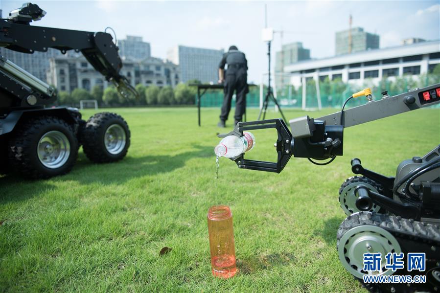 선진칸(沈晉侃) 씨가 폭발물 제거 로봇을 이용해 컵에 물을 따르고 있다. [7월 26일 촬영/사진 출처: 신화망]