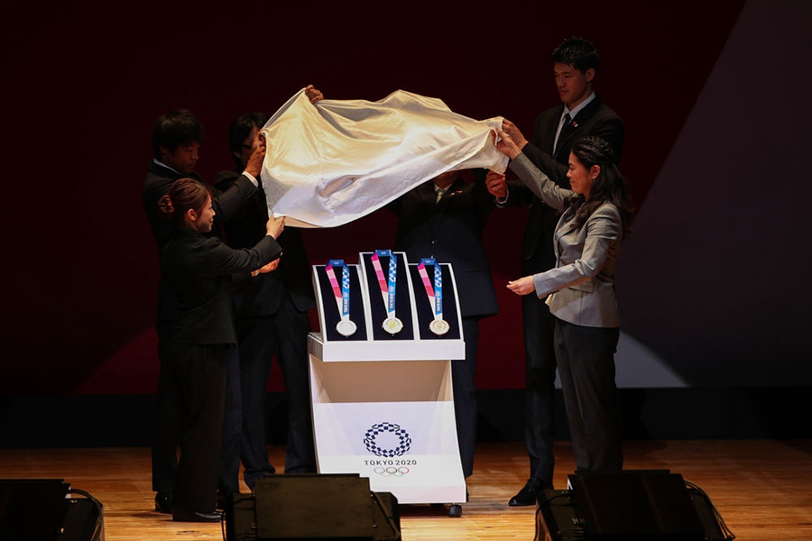 7월 24일 2020 도쿄올림픽 D-365일 기념행사장, 행사 관계자들이 도쿄 올림픽 메달을 공개하고 있다. [사진 출처: 신화사]