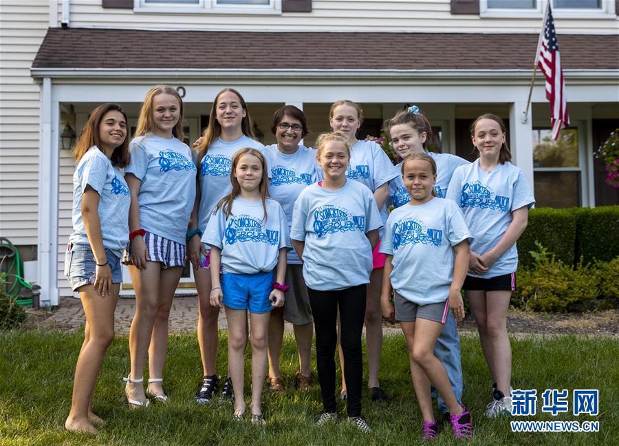 7월 27일 린•베라트(뒷줄 가운데) 씨와 9명의 딸이 미국 뉴저지주에 위치한 중국어 선생님 집 앞에서 단체사진을 찍는 모습 [사진 출처: 신화망]