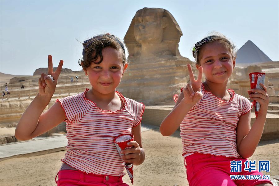 지난달 19일 이집트 카이로 기자(Giza)에 있는 피라미드 관광지역에서 두 명의 아이가 손에 든 아이스크림을 선보이고 있다. [사진 출처: 신화망]