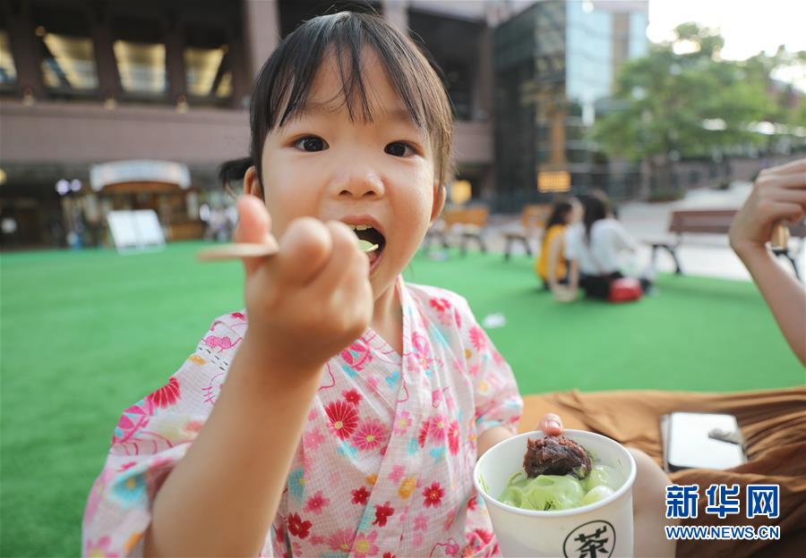 지난달 30일 한 여자아이가 일본 도쿄에서 말차 아이스크림을 먹고 있다. 일본의 독특한 맛인 말차 아이스크림에는 팥, 밤, 경단 등 일본에서 흔히 볼 수 있는 전통 고명이 들어가 있다. [사진 출처: 신화망]
