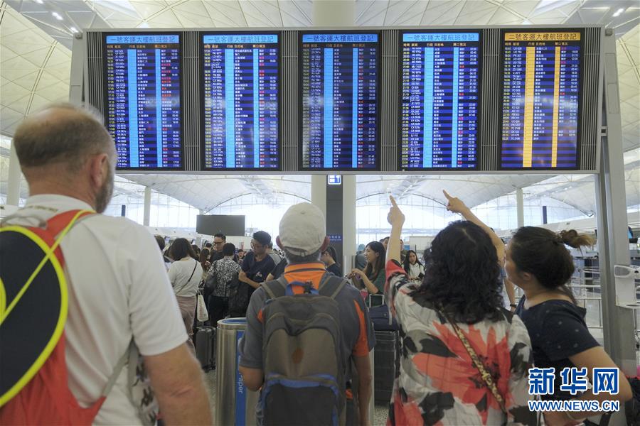 관광객들이 홍콩국제공항 운항정보안내 모니터에서 항공편 정보를 찾고 있다. [8월 14일 촬영/사진 출처: 신화망]