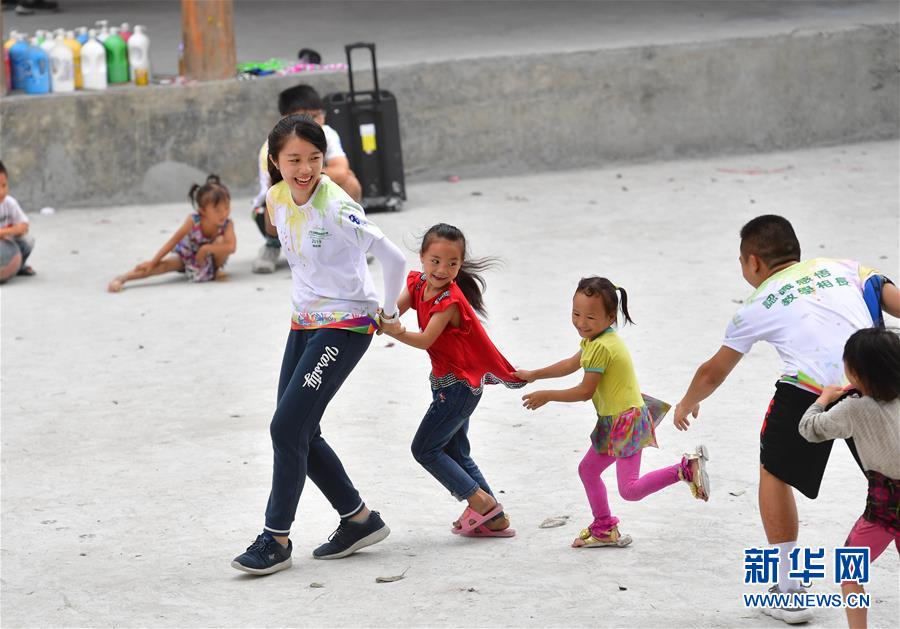 자원봉사자들이 우잉(烏英) 묘족(苗族) 마을 어린이들과 함께 게임을 즐기고 있다. [8월 10일 촬영/사진 출처: 신화망]