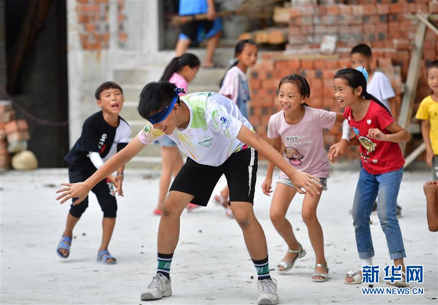 자원봉사자와 우잉(烏英) 묘족(苗族) 어린이들이 게임을 즐기고 있다. [8월 10일 촬영/사진 출처: 신화망]