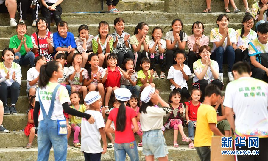 자원봉사자와 우잉(烏英) 묘족(苗族) 어린이들이 공연을 관람하고 있다. [8월 10일 촬영/사진 출처: 신화망]