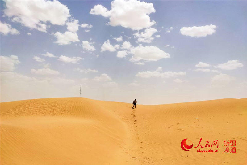 관광객이 타커라마간(塔克拉瑪幹) 사막 모래언덕 위로 올라가고 있다. [사진 출처: 인민망]