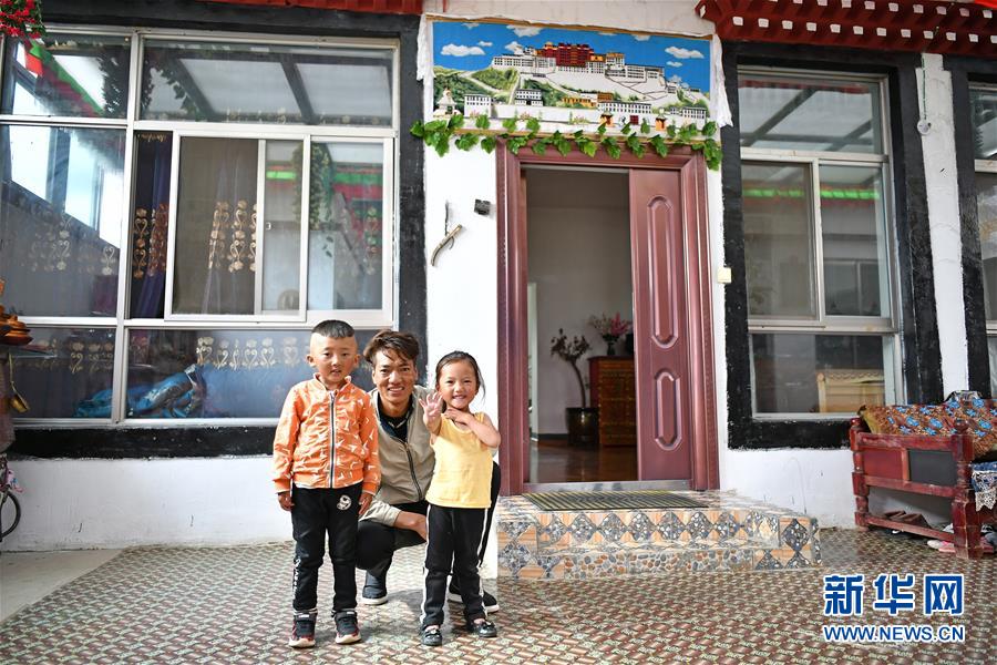 마을 주민 줘지주메이(多吉久美, 가운데) 씨가 아들 간단둬지(甘旦多吉•6세, 왼쪽)와 딸 자시춰무(扎西措姆•4세)와 함께 기념사진을 찍고 있다. [8월 8일 촬영/사진 출처: 신화망]