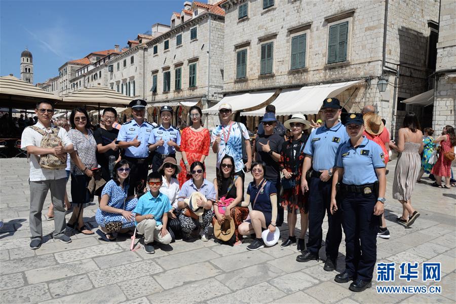 8월 9일 제2차 중국-크로아티아 경찰 관광시즌 합동순찰에 나선 경찰관들이 크로아티아 남부 도시 두브로브니크에서 관광객들과 기념사진을 찍고 있다. [사진 출처: 신화망]