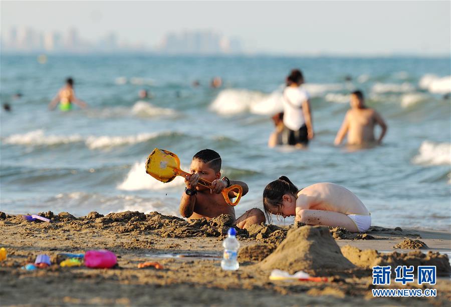 7월 15일 아이들이 스페인 발렌시아 해변에서 놀고 있다. [사진 출처: 신화망]