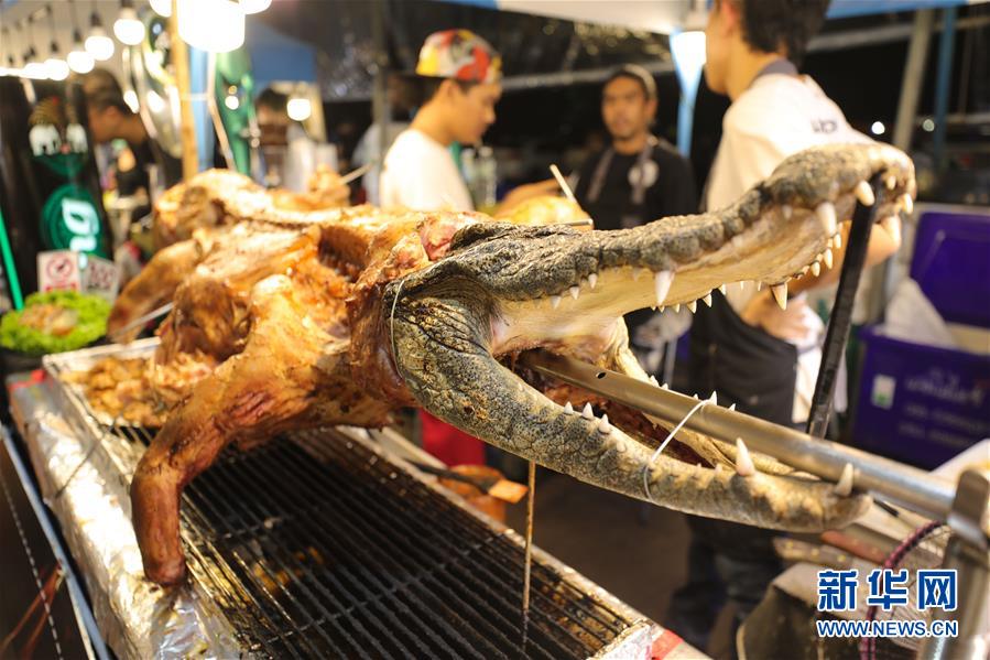8월 10일 태국 방콕 모 야시장, 상인이 악어구이를 팔고 있다. [사진 출처: 신화망]