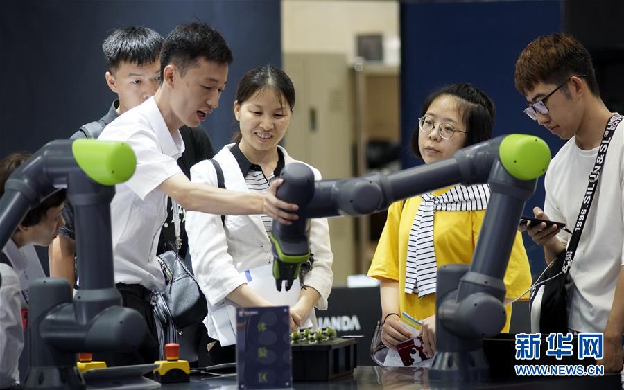 8월 20일 한 스마트 로봇 업체 기술진이 참관객들에게 로봇 팔에 대해 설명하는 모습 [사진 출처: 신화망]