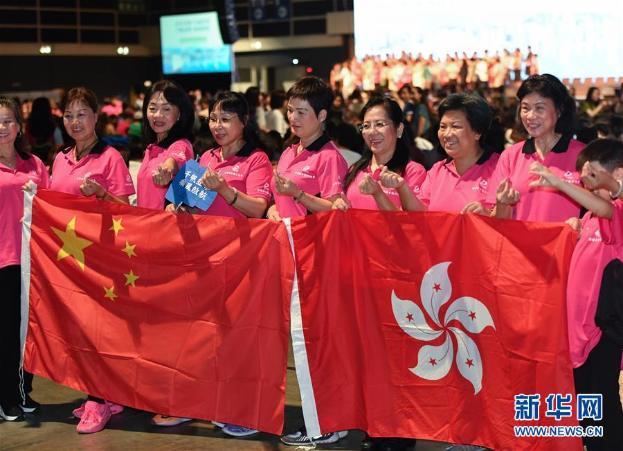 지난 25일 홍콩부녀자수호집회에 참가한 사람들이 국기와 홍콩특별행정구기를 함께 사진 찍고 있다. [사진 출처: 신화망]