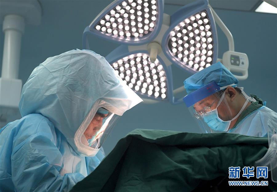 7월 31일 허난(河南)성 전염병병원 수술실, 펑슈링(馮秀嶺, 왼쪽) 전문의가 ‘완전무장’을 한 상태로 에이즈 환자 수술을 집도하고 있다. [사진 출처: 신화망]