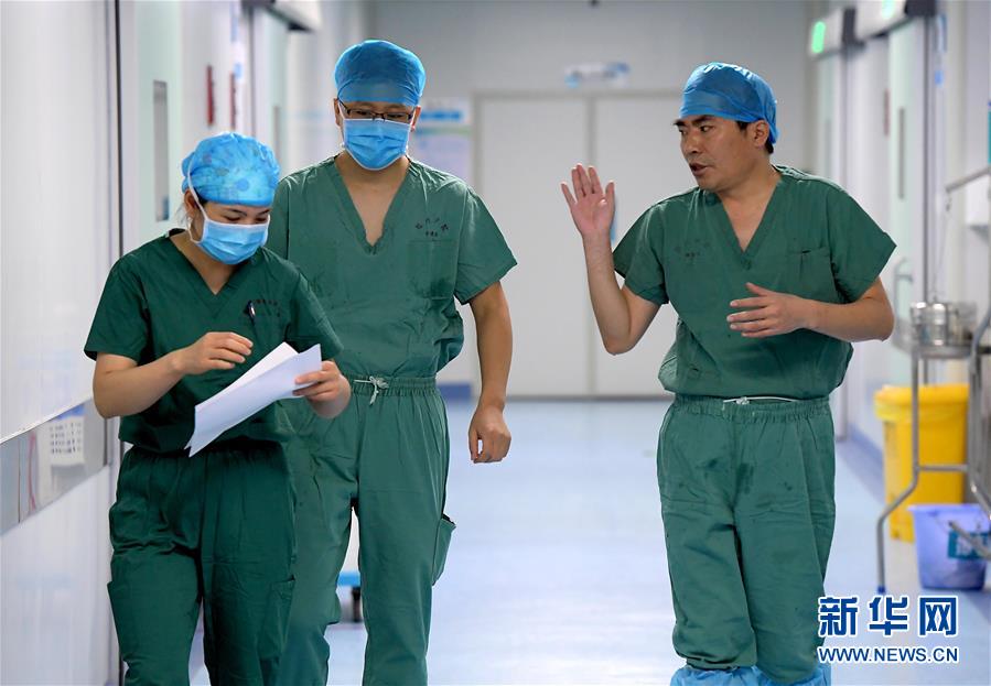 7월 31일 허난(河南)성 전염병병원 수술실, 수술을 마친 펑슈링(馮秀嶺, 오른쪽) 전문의가 의료진과 수술에 대해 이야기를 나누고 있다. [사진 출처: 신화망]