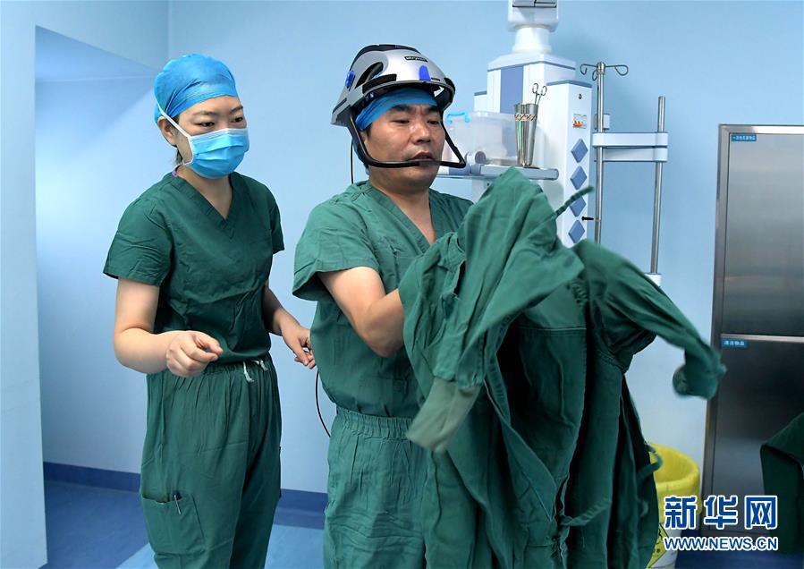 7월 31일, 펑슈링(馮秀嶺) 전문의가 수술실 앞에서 수술복을 입고 있다. [사진 출처: 신화망]