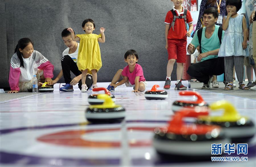참관객들이 베이징 동계올림픽 전시관에서 컬링을 체험하는 모습 [8월 21일 촬영/사진 출처: 신화망]