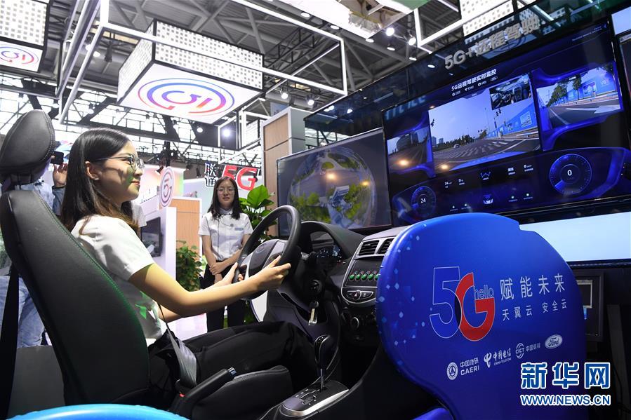 박람회장을 찾은 참관객이 ‘5G 원거리 운전’ 기술을 체험하고 있다. [사진 출처: 신화망]