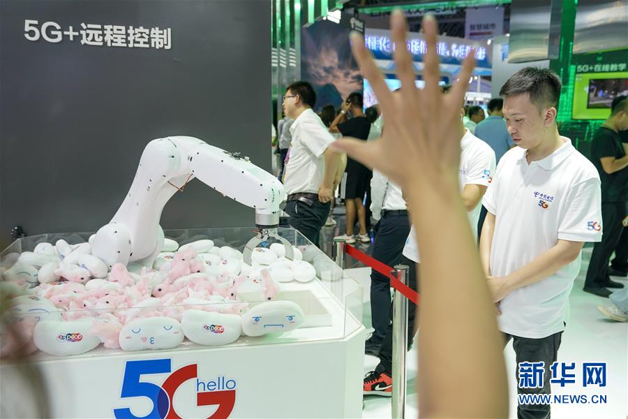 차이나텔레콤(中國電信) 전시 부스를 찾은 참관객이 5G 원거리 로봇 제어 기술을 체험하고 있다. [사진 출처: 신화망]