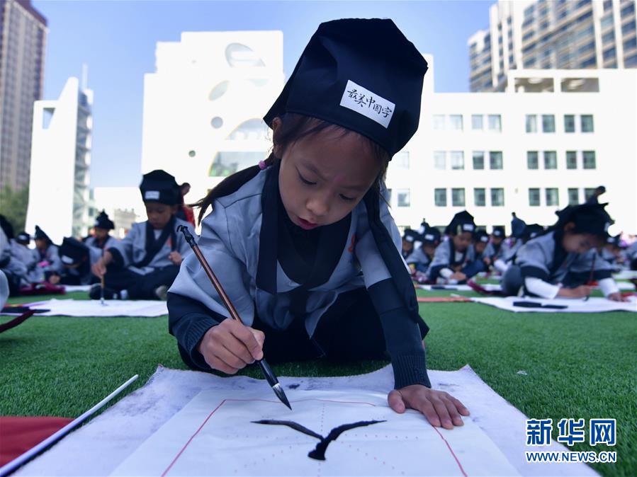 칭하이(靑海)성 시닝(西寧)시 원후이(文匯)초등학교 1학년 신입생들이 ‘개필례(開筆禮)’ 의식에 참가해 ‘사람 인(人)’을 적고 있다. [사진 출처: 신화망]