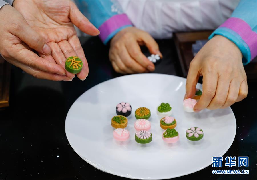 지난 10일 한국 서울의 한국 전통 음식 연구소에서 윤숙자(오른쪽) 소장과 제자들이 눌러 만든 다식을 접시에 옮기고 있다. [사진 출처: 신화망]