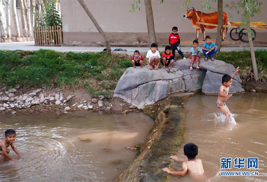 지난 1일 어린아이들이 카스(喀什)시 파하타이커리(帕哈太克里)향 강가에서 놀고 있다. [사진 출처: 신화망]