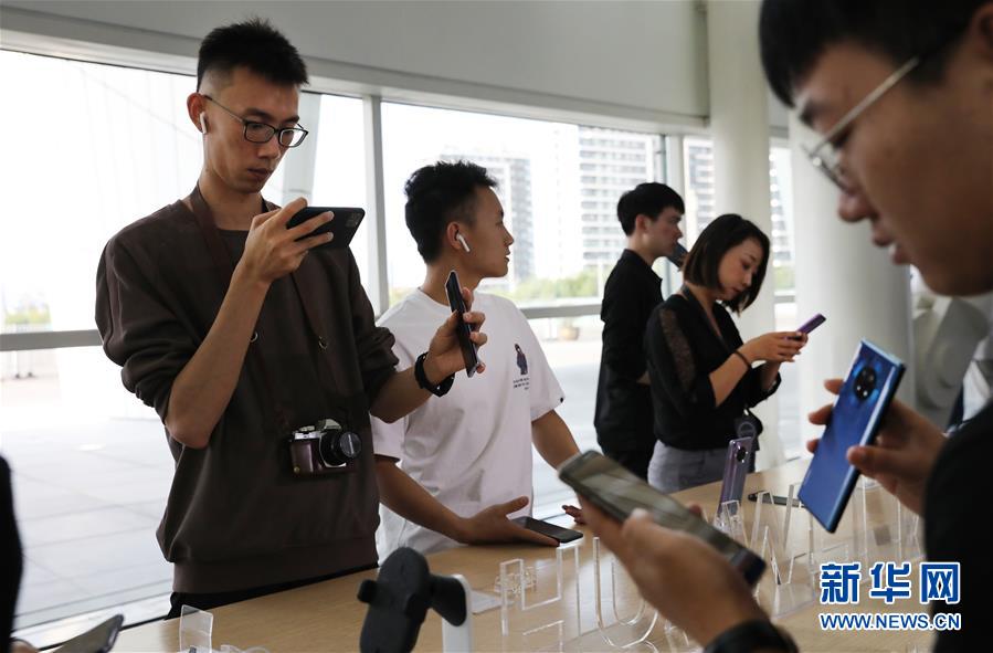 지난 26일 발표회장에서 사람들이 신제품 핸드폰을 체험하고 있다. [사진 출처: 신화망(新華網)]