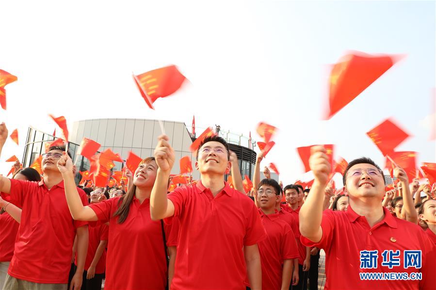 지난 26일 광둥(廣東) 둥관(東莞) 민영•궈마오(國貿) 중심에서 웨강아오(粵港澳: 광둥-홍콩-마카오) 청년들이 국기를 흔들며 ‘가창조국(歌唱祖國)’을 합창하고 있다. (사진 출처: 신화망)