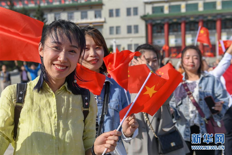 지난 26일 지린(吉林)성 창춘(長春)시 문화광장에서 중화전국청년연합회 위원들과 청년대표가 국기를 흔들며 기념 촬영을 하고 있다. (사진 출처: 신화망)