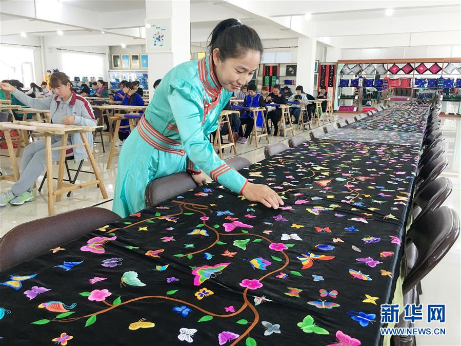 지난 18일 자수 작업에 참여한 여성이 7000마리 나비를 수놓은 긴 두루마리를 감상하고 있다. [사진 출처: 신화망]