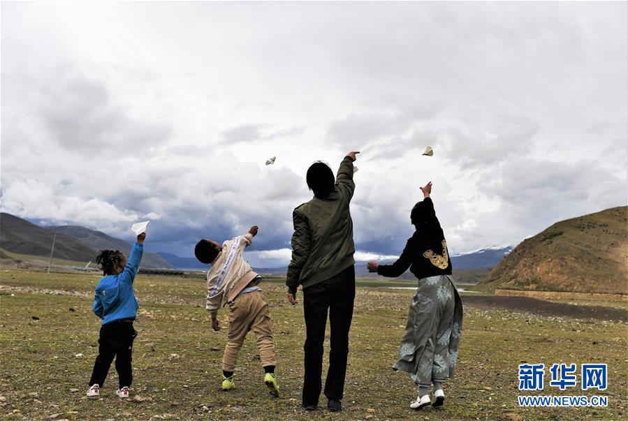 젠러이시(堅熱益西•왼쪽 두번째)가 목가지역에서 동생들과 함께 종이비행기를 날리고 있다. [7월 13일 촬영/사진 출처: 신화망]