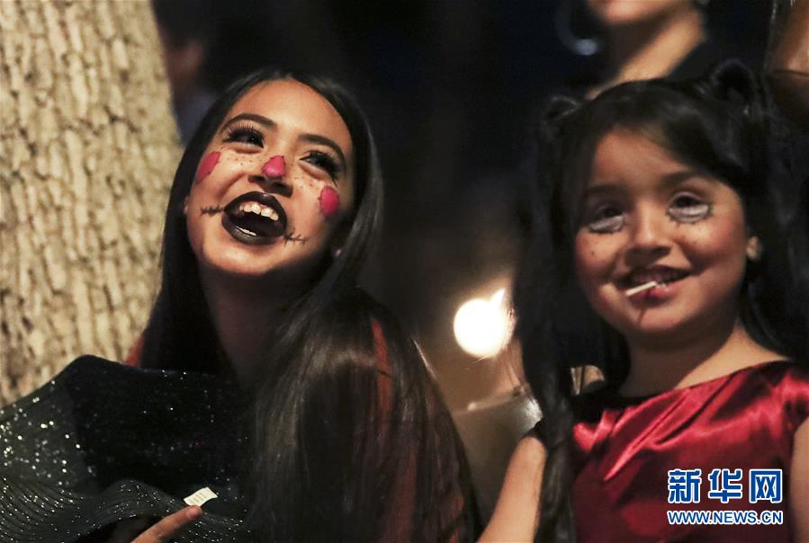 10월 26일, 미국 캘리포니아주 애너하임에서 여자 어린이들이 할로윈 퍼레이드를 구경하고 있다. [사진 출처: 신화망]