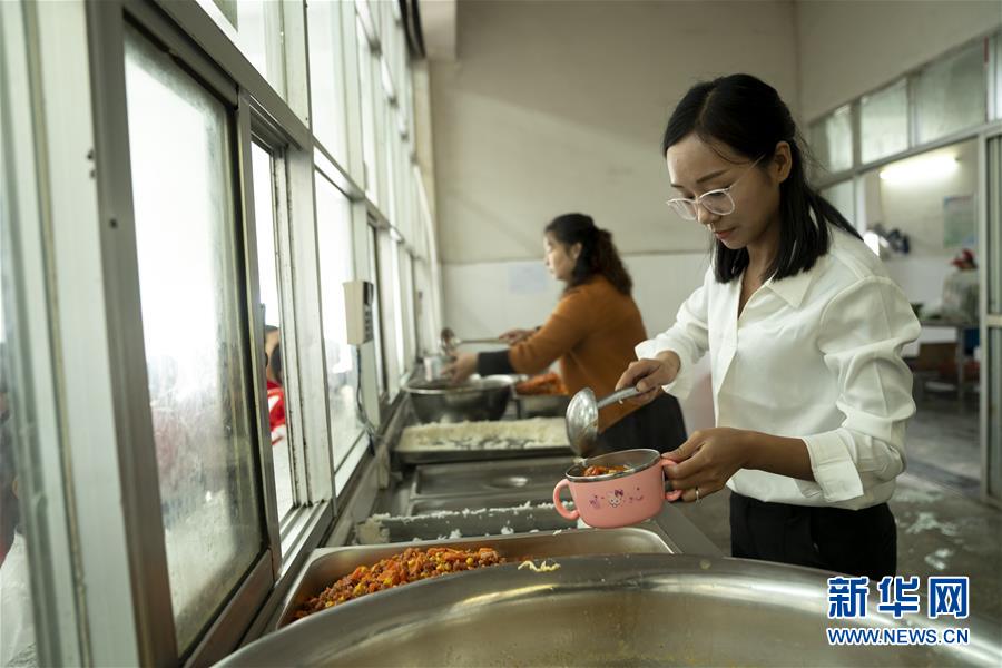 방룽(方榮)은 희망 초등학교 식당에서 급식을 돕고 있다. [10월 11일 촬영/사진 출처: 신화망]