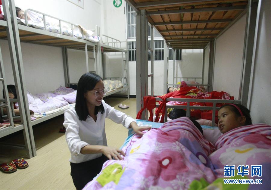 희망 초등학교 학생 기숙사에서 방룽(方榮)은 아이들과 이야기를 나누고 있다. [10월 10일 촬영/사진 출처: 신화망]
