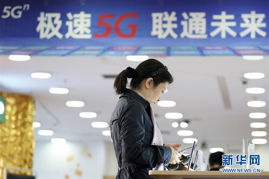 10월 31일 베이징의 한 차이나유니콤 영업점에서 소비자가 5G 휴대폰을 체험하고 있다. [사진 출처: 신화망]