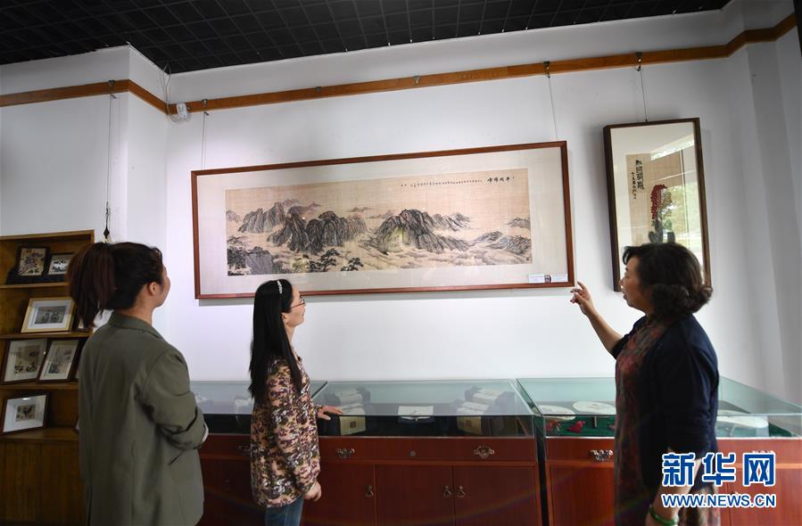 장샤오훙(張小紅•오른쪽)이 모시자수 박물관에서 방문객에게 자신의 자수 작품을 소개하고 있다. [10월 23일 촬영/사진 출처: 신화망]