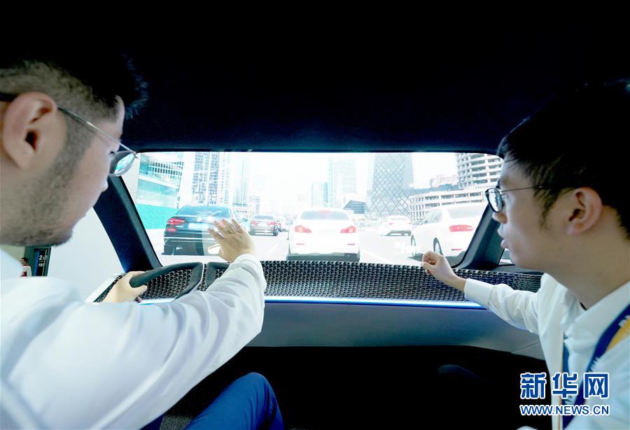 지난 5일 엔지니어(오른쪽)가 제2회 중국국제수입박람회 자동차 전시구역에 있는 BMW 비전 iNEXT 디지털체험관에서 관람객에게 설명하고 있다. [사진 출처: 신화망]