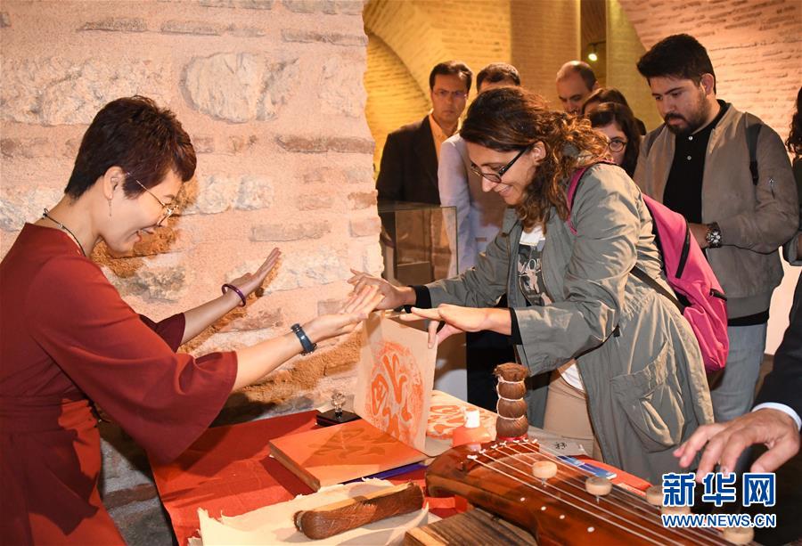 10월 18일 터키 이스탄불에서 열린 ‘일대일로’ 상하이비물질문화유산 전시회에서 관람객(오른쪽)이 목판 잉크 공예를 체험하고 있다. [사진 출처: 신화망]