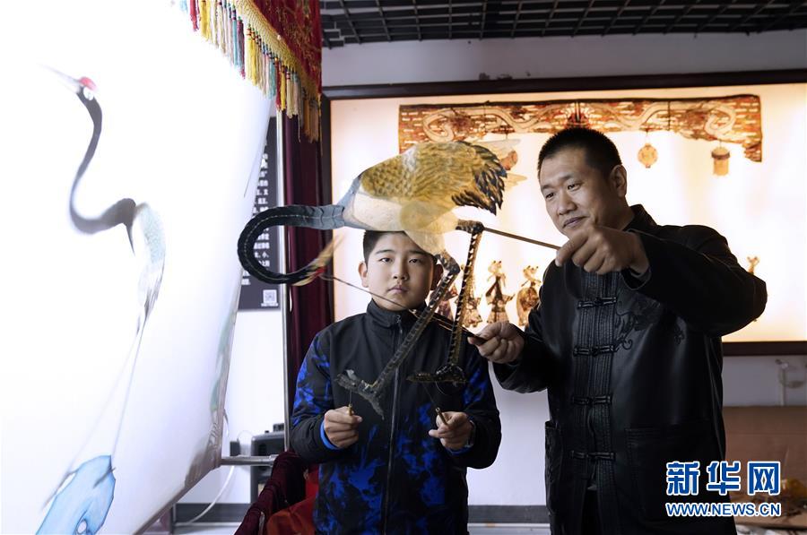 11월 10일 궈바오(郭宝•오른쪽) 씨는 피잉(皮影) 전승관에서 아이들에게 피잉을 가르치고 있다. [사진 출처: 신화망]