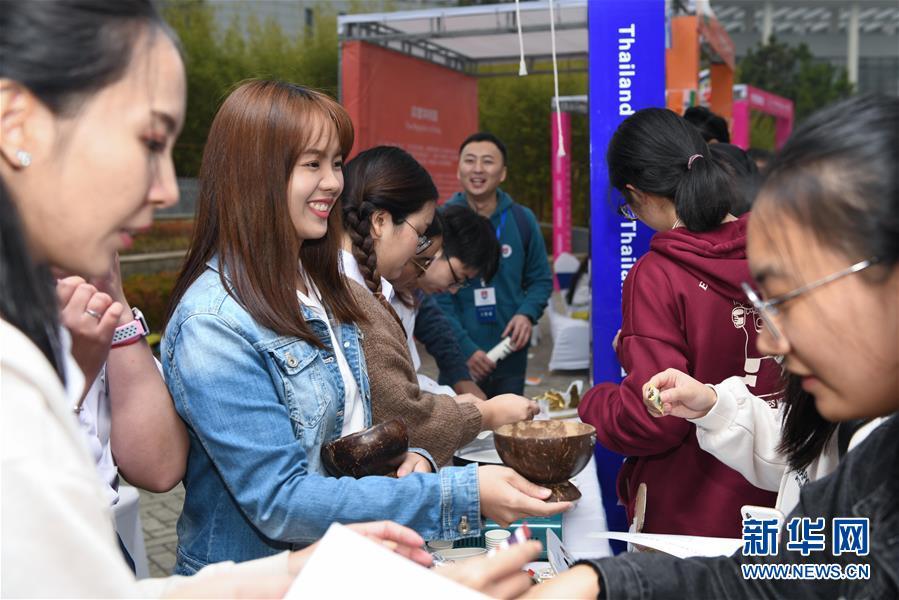 지난 17일 태국 유학생(왼쪽 두번째)이 국제문화제에서 관객에게 시식을 권하고 있다. [사진 출처: 신화망]