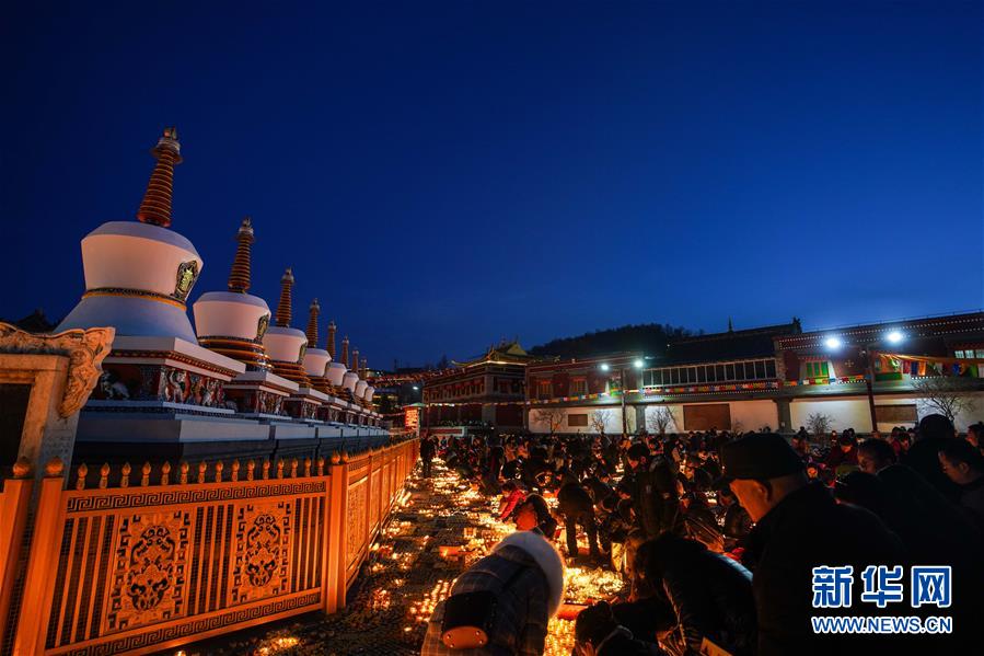 지난 21일 신도가 탑이사(塔爾寺) 광장에서 쑤유덩(酥油燈)에 불을 붙이고 있다. [사진 출처: 신화망]