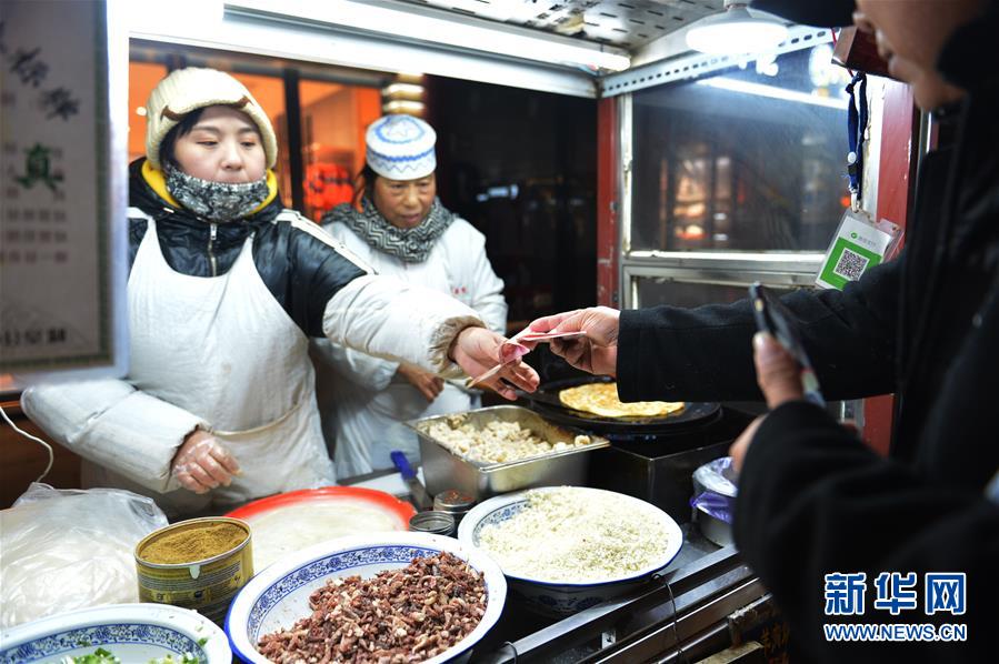 지난 27일, 한 여행객이 카이펑 종루 야시장에 소재한 음식점에서 결제를 하고 있다. [촬영/신화사 기자 런펑페이(任鵬飛)]