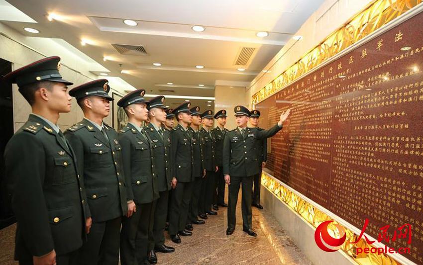 마카오 주둔 부대 군인이 출입국사무소 신 청사의 벽에 새겨진 주둔법을 학습하고 있다. [12월 2일 촬영/사진 출처: 인민망]