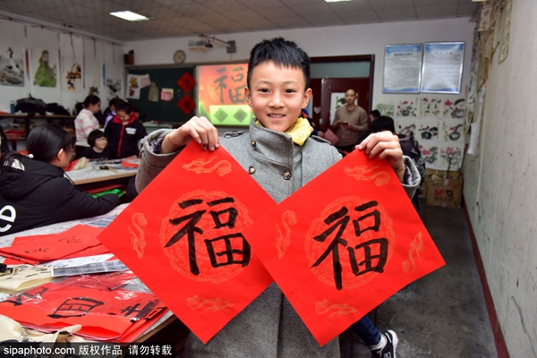 허베이성 스자좡 신러시 청소년센터 서예반 아이들이 직접 쓴 춘롄을 선보이고 있다. [1월 4일 촬영/사진 출처: Sipaphoto]