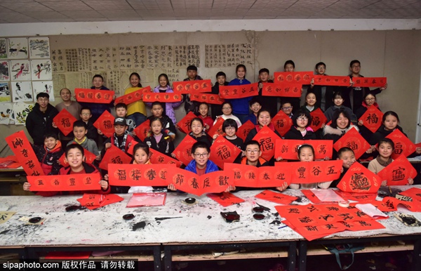 허베이성 스자좡 신러시 청소년센터 서예반 아이들이 직접 쓴 춘롄을 선보이고 있다. [1월 4일 촬영/사진 출처: Sipaphoto]