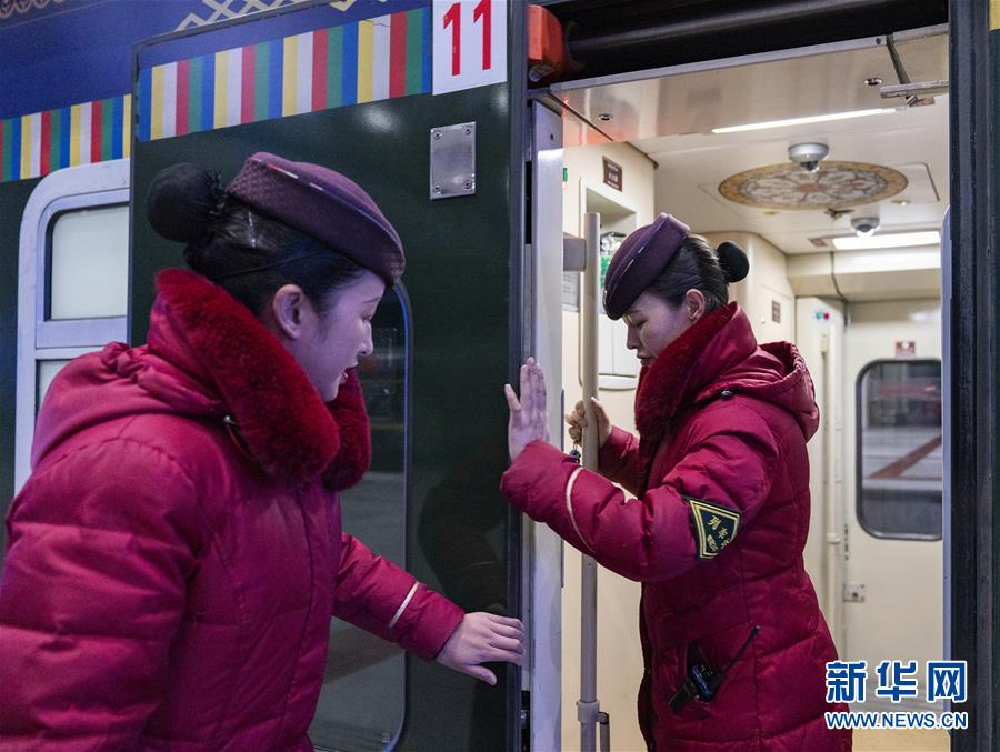 발차 전에 궁주취전(오른쪽)이 승무원과 함께 열차 문을 검사하고 있다. [1월 12일 촬영/사진 출처: 신화망]
