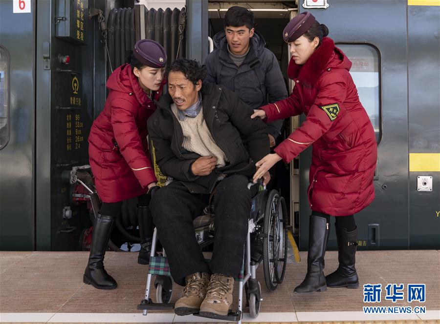 궁주취전(오른쪽 1번째)이 동료와 함께 승객이 열차에서 내리는 것을 돕고 있다. [1월 12일 촬영/사진 출처: 신화망]