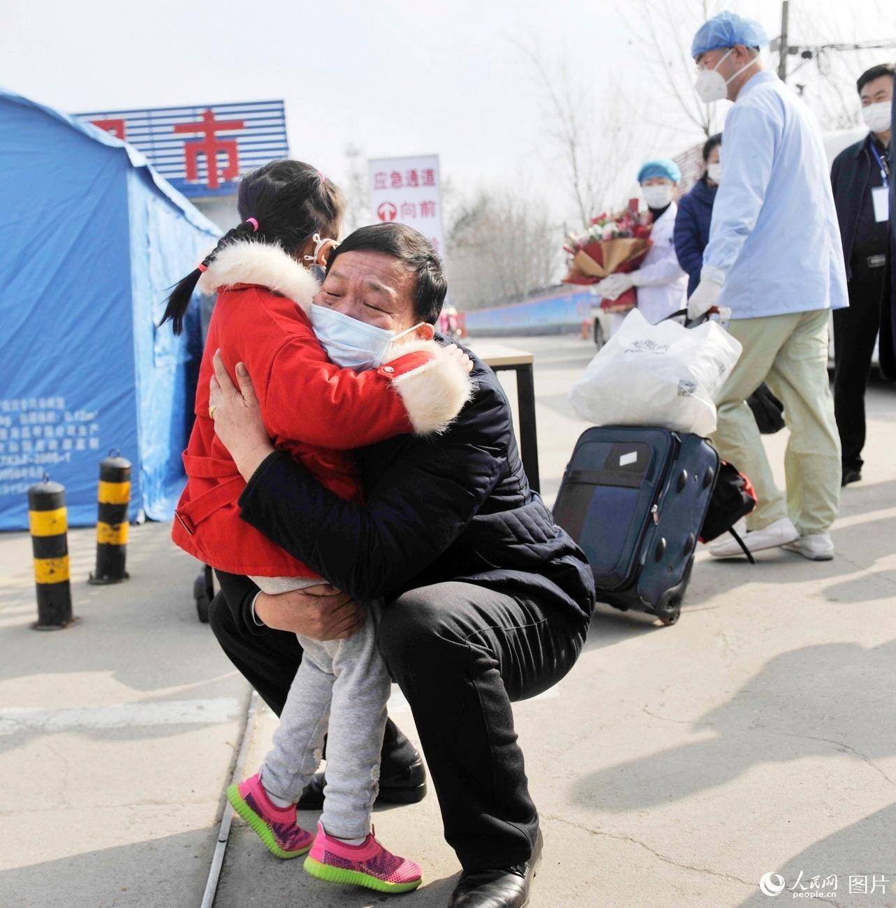5세 어린이 환자가 건강을 회복하고 퇴원해 가족과 부둥켜안고 있다. [사진 출처: 인민망]